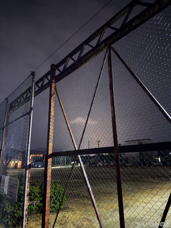 iPhone 17 Pro カメラ 夜の運動場の錆びたフェンス