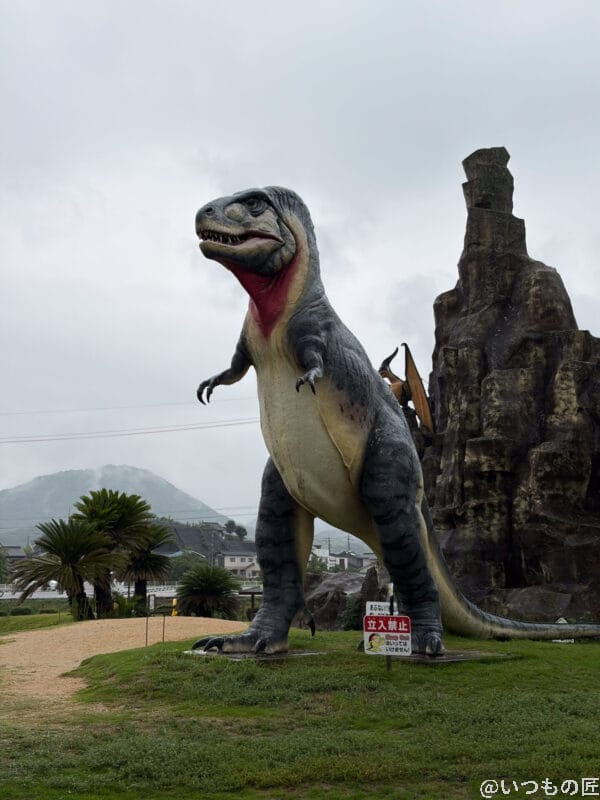 iPhone17 カメラ 雨の日のティラノサウルスの巨大オブジェ