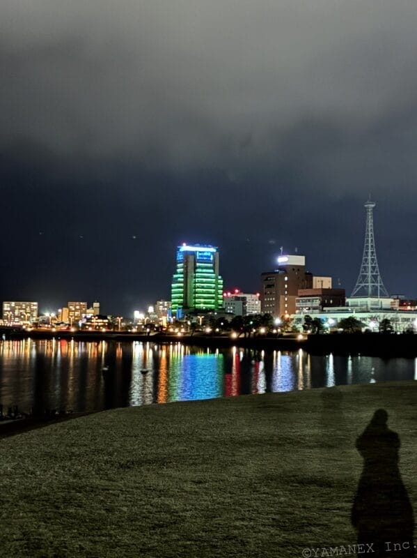 海の向こうに見える街並みを暗所撮影 | iphone review.jp iPhone17e カメラ 海の向こうに見える街並みを暗所撮影